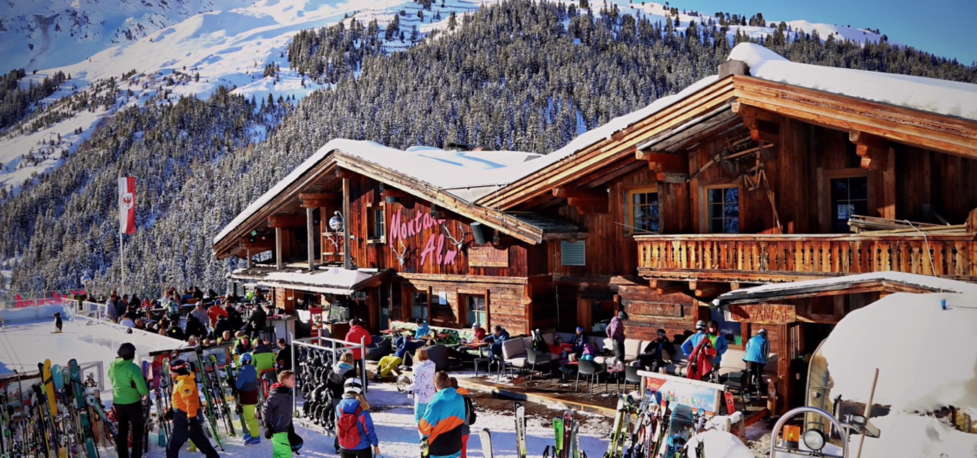 Hölzerne Skihütte in Montafon mit Skifahrern und Schneebergen.