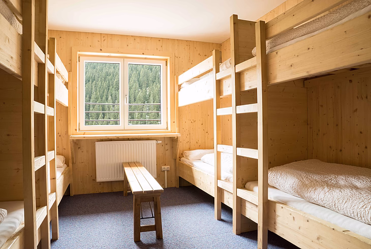 Mehrbettzimmer im Alpincenter Hochfügen mit Sitzgelegenheit und Fenster